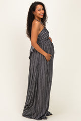 woman wearing a black and white striped maternity maxi dress and holding her baby bump