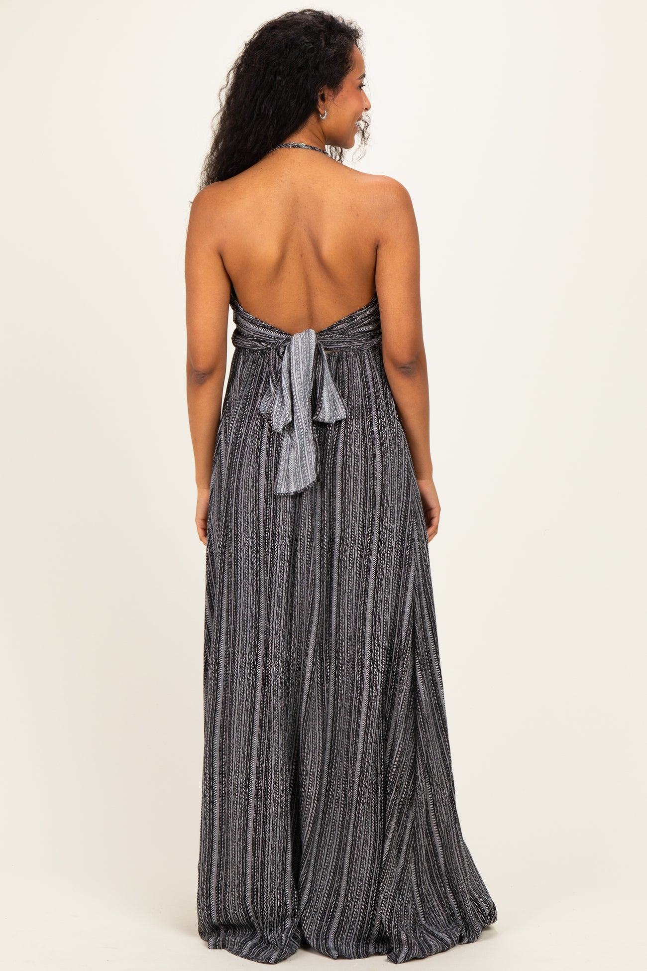 woman wearing a black and white striped strapless maternity dress with a tied back detail