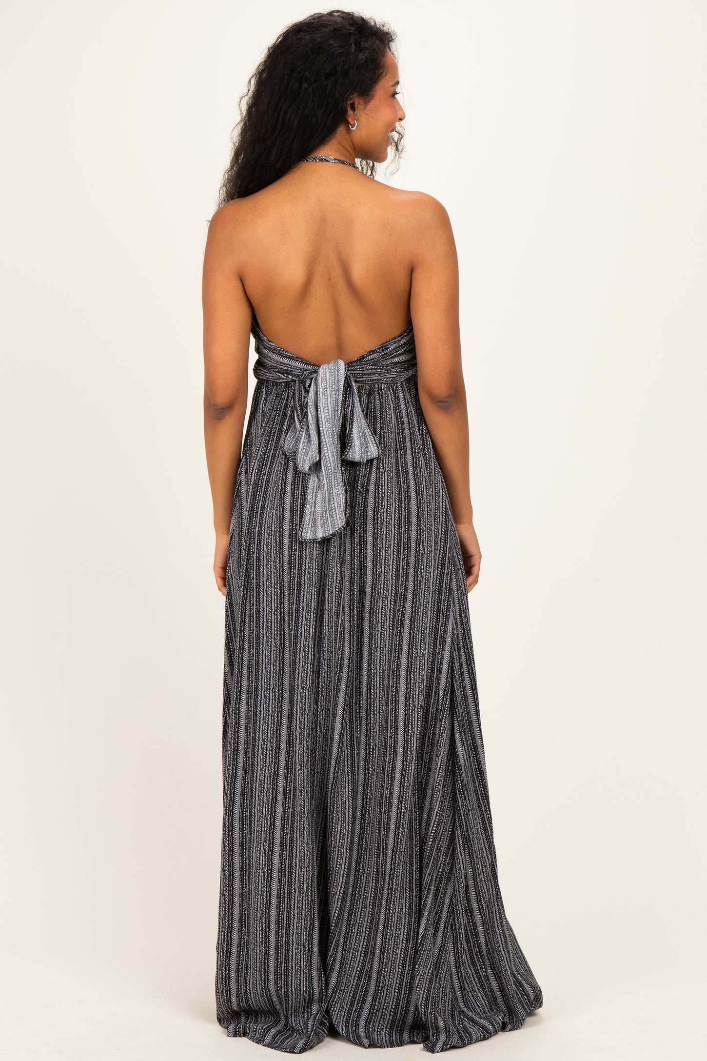 woman wearing a black and white striped strapless maternity dress with a tied back detail