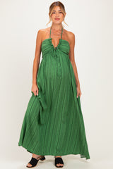 woman wearing a green striped maternity maxi dress with a halter neck and a visible baby bump