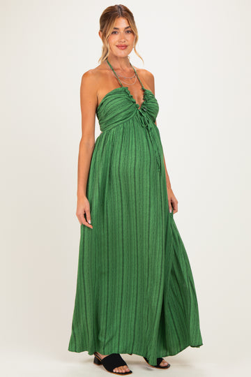 woman wearing a green striped strapless maternity dress with a tied front and a visible baby bump