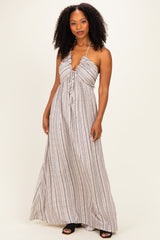 woman wearing a striped maxi dress with a halter neckline and tie-front detailing
