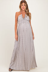 woman wearing a striped maternity maxi dress with a halter neckline and ruffled detailing, showcasing a baby bump