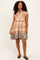 woman wearing a patterned brown short sleeve dress with a decorative hem and ruffled sleeves