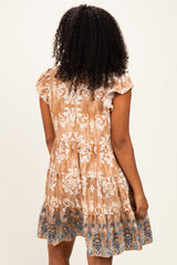 woman wearing a brown short sleeve dress with intricate white embroidery and a flared skirt