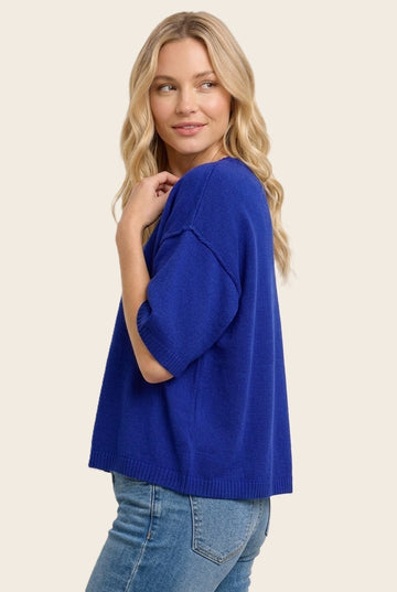 woman wearing a vibrant blue oversized knit sweater paired with light blue jeans