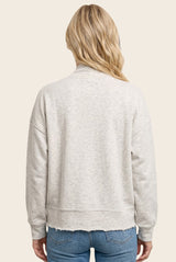 woman wearing a light gray cropped sweatshirt with slouchy shoulders and raw hem, seen from the back