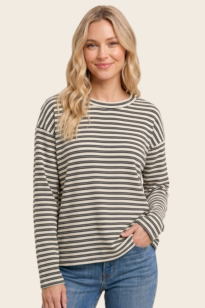 woman wearing a black and cream striped long sleeve top with a relaxed fit and round neckline