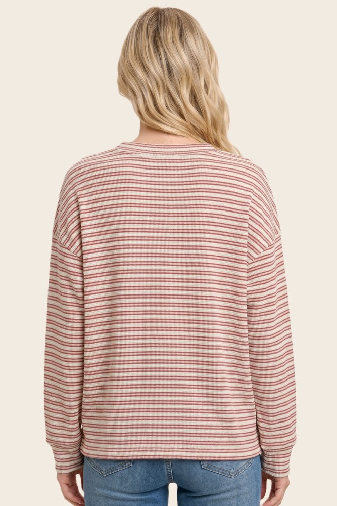 woman wearing a pink and cream striped long sleeve sweater with a relaxed fit, seen from the back