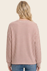 woman wearing a pink and cream striped long sleeve sweater with a relaxed fit, seen from the back
