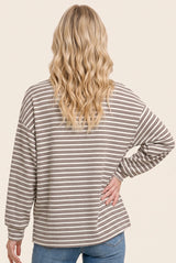 woman wearing a beige and brown striped long sleeve top, seen from the back with loose fit and relaxed style