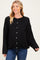 woman wearing a black oversized cardigan, smiling and showcasing her baby bump with blue jeans