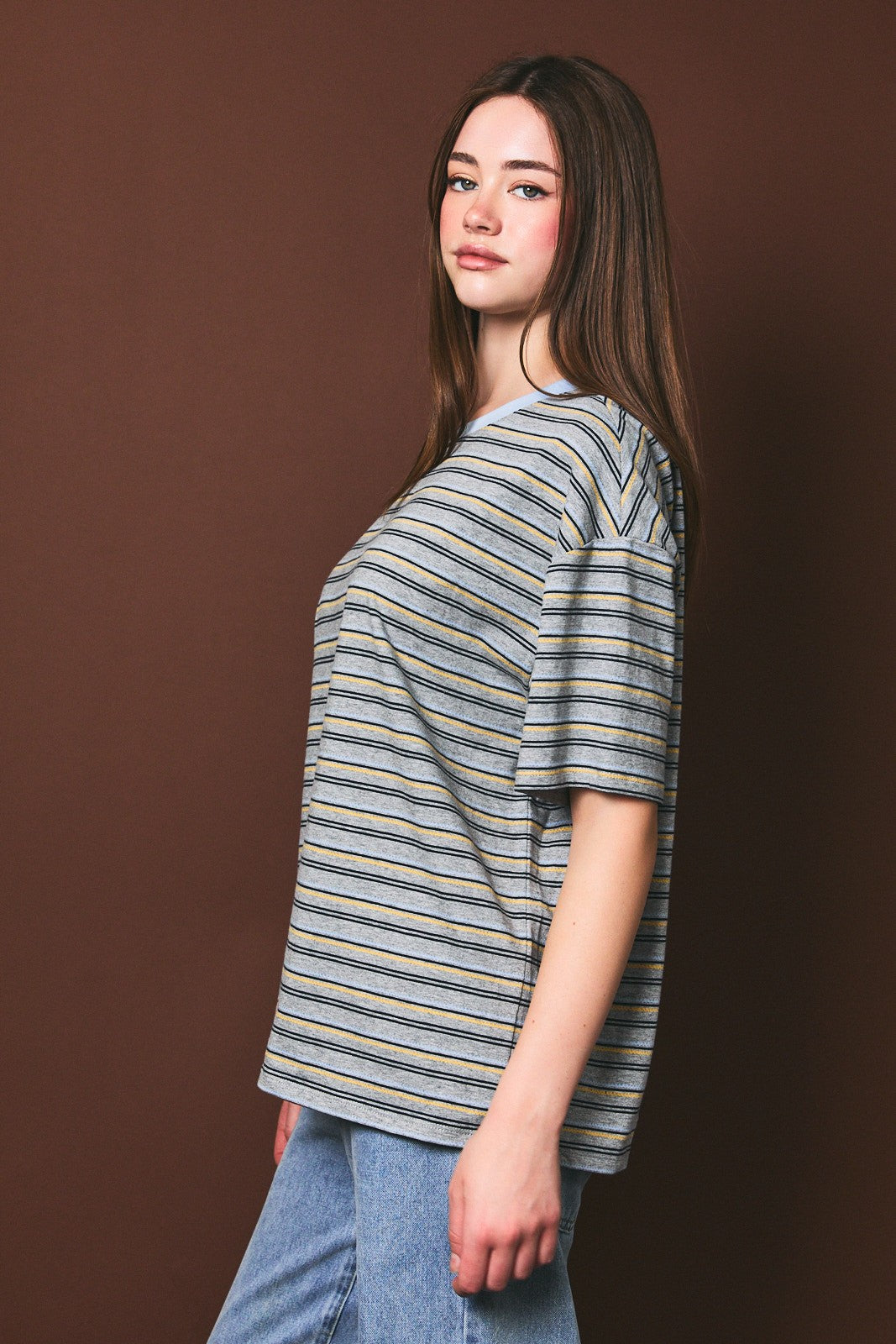 woman wearing a striped oversized t-shirt with short sleeves paired with high-waisted denim jeans