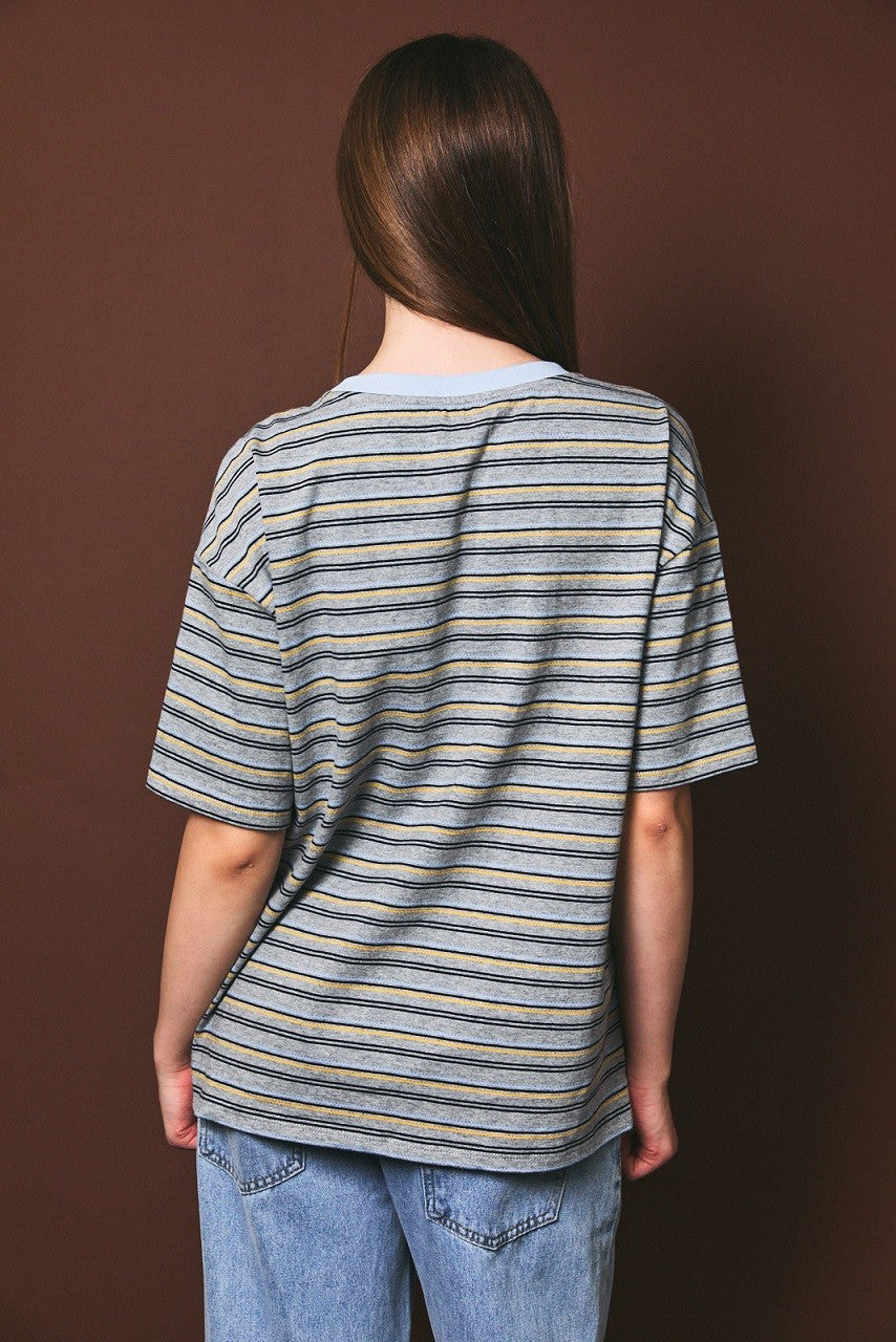 woman wearing a gray and navy striped oversized t-shirt with short sleeves and loose fit, viewed from the back