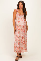 woman wearing a floral pink maternity maxi dress with ruffle straps and a visible baby bump