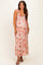 woman wearing a floral pink maternity maxi dress with ruffle straps and a visible baby bump