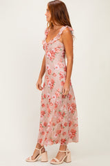 woman wearing a pink floral maxi dress with ruffled straps and a flowing skirt
