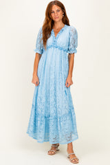 woman wearing a light blue lace maxi dress with puff sleeves and a tiered skirt