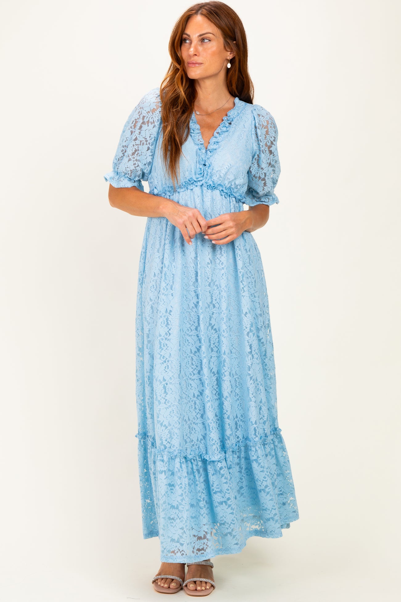 woman wearing a light blue lace maxi dress with short puff sleeves and a tiered hem