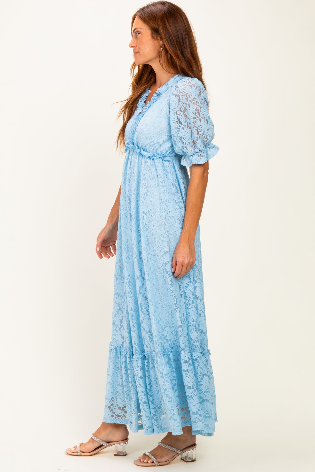 woman wearing a light blue lace maxi dress with puff sleeves and a tiered skirt