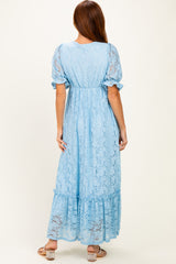woman wearing a light blue lace maxi dress with puff sleeves and a tiered hem, shown from the back