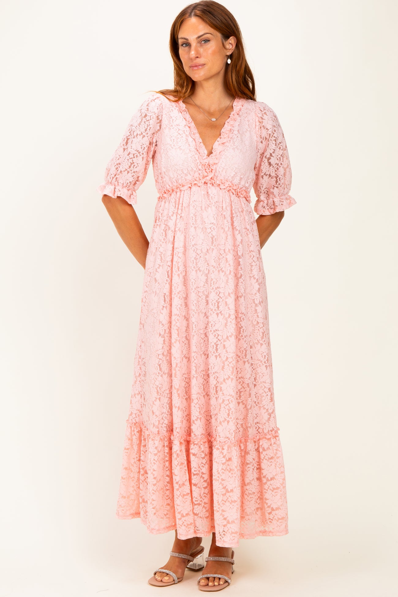woman wearing a pink lace maxi dress with a v-neckline and puff sleeves