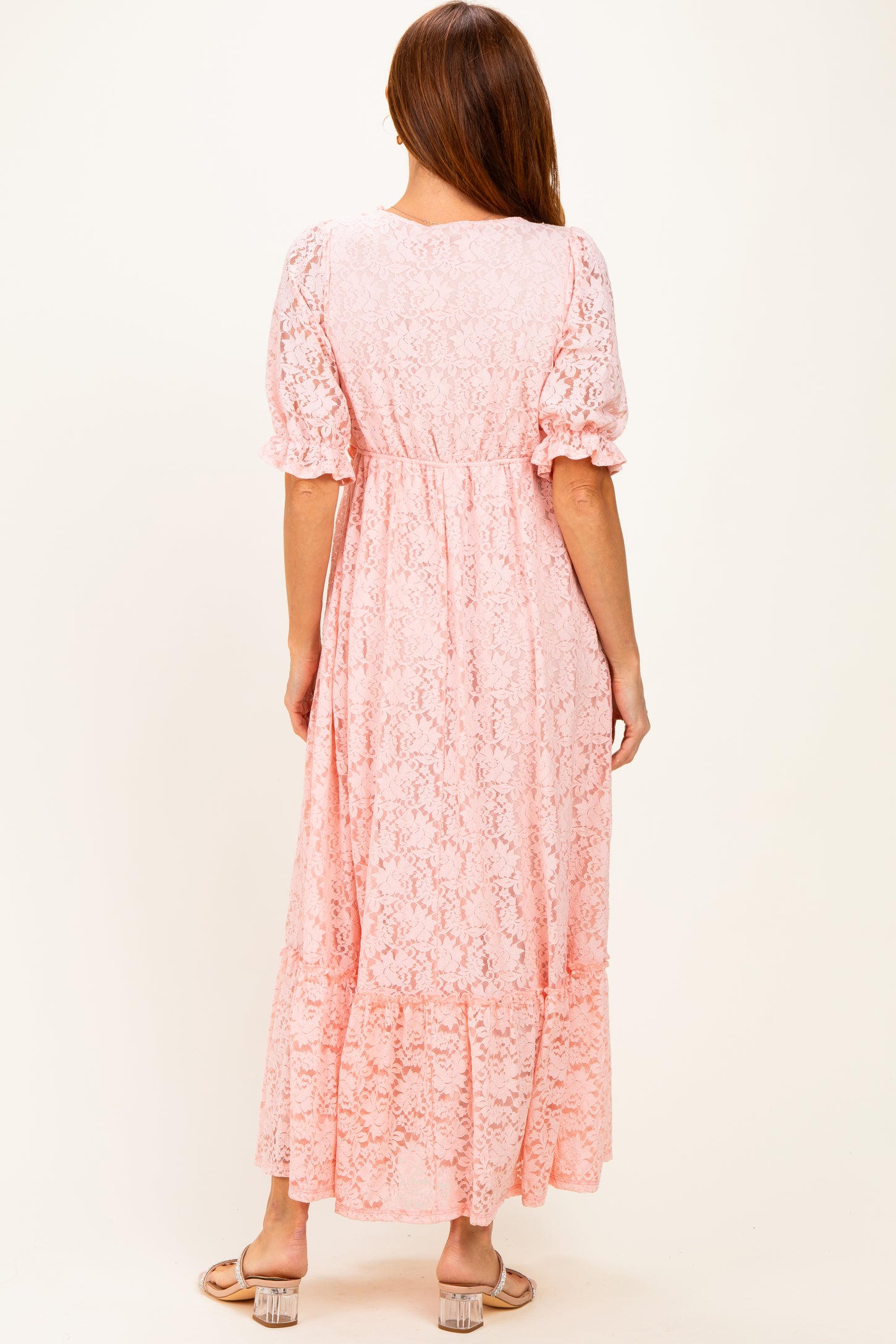 woman wearing a pink lace maxi dress with puff sleeves and tiered hem, shown from the back