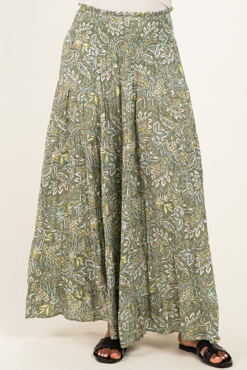 woman wearing a green floral patterned maxi skirt with an elastic waistband and flowing silhouette