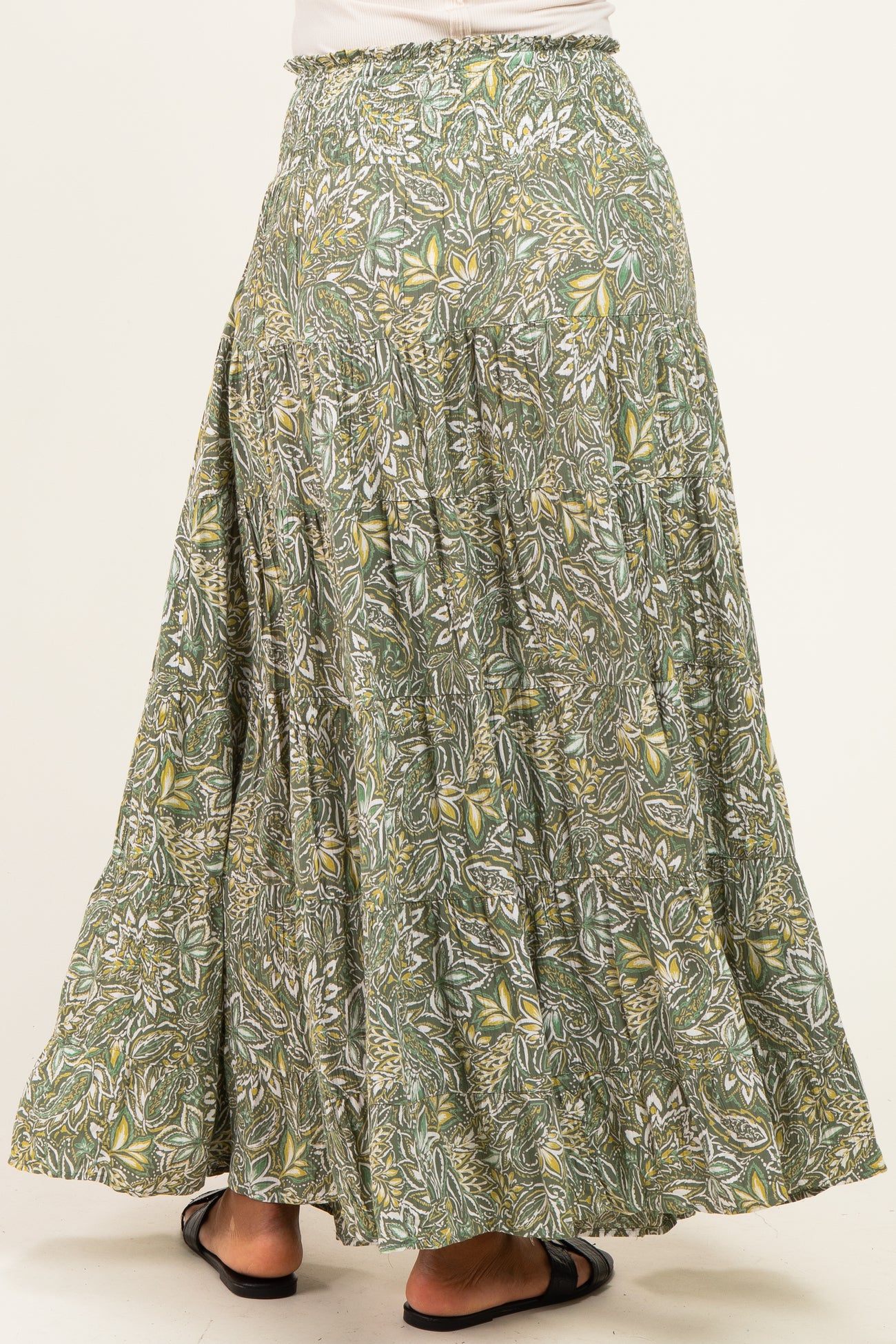 woman wearing a flowy green and yellow floral maxi skirt showing back view
