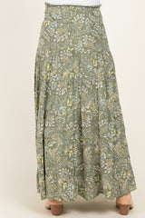 woman wearing a green floral maternity maxi skirt with a flowy design, showcasing a gathered waistband and tiered style