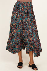 woman wearing a black floral maxi skirt with a tiered hem and elastic waistband, paired with black slide sandals