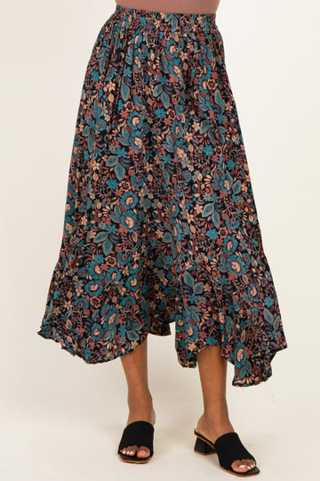 woman wearing a black floral maxi skirt with a tiered hem and elastic waistband, paired with black slide sandals