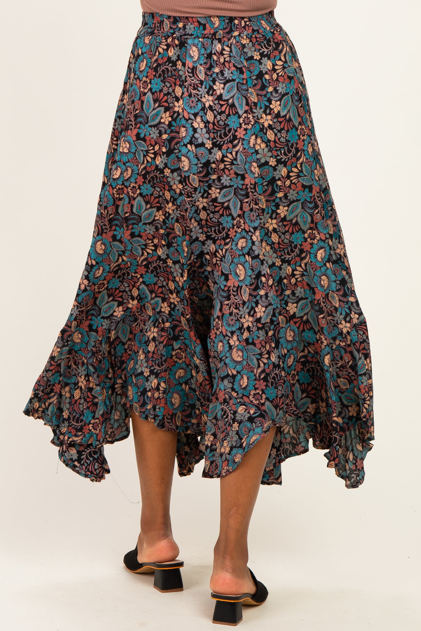woman wearing a floral print midi skirt with a ruffled hem and back split, view from the back