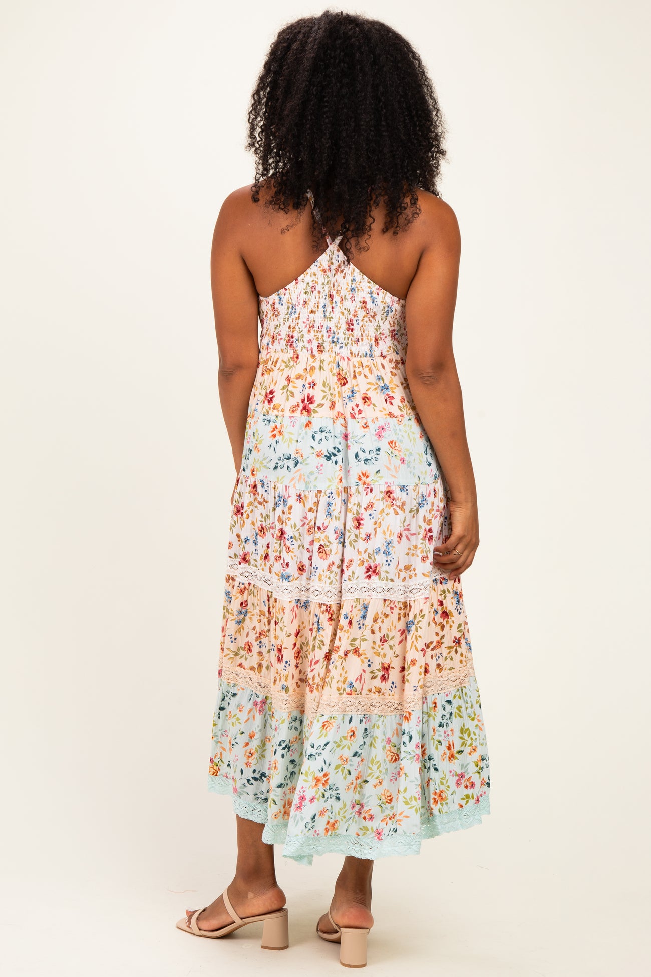woman wearing a flowy multicolor floral maxi dress with a smocked back and adjustable straps