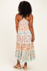 woman wearing a flowy multicolor floral maxi dress with a smocked back and adjustable straps