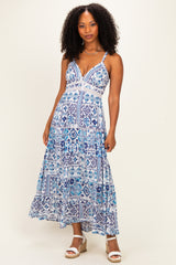 woman wearing a blue and white patterned maxi dress with a plunging neckline and spaghetti straps