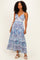 woman wearing a blue and white patterned maxi dress with a plunging neckline and spaghetti straps