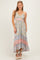 woman wearing a light blue floral maxi dress with adjustable straps and tiered ruffles at the hem