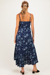 woman wearing a navy blue floral maternity maxi dress with adjustable straps and a tiered skirt