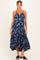 woman wearing a navy blue floral maternity dress with spaghetti straps and a tiered skirt, showing her baby bump