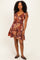 woman wearing a colorful short sleeve floral print dress with a flared skirt and a v-neckline