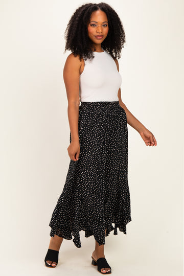 woman wearing a white sleeveless top and a black polka dot maxi skirt with a ruffled hem