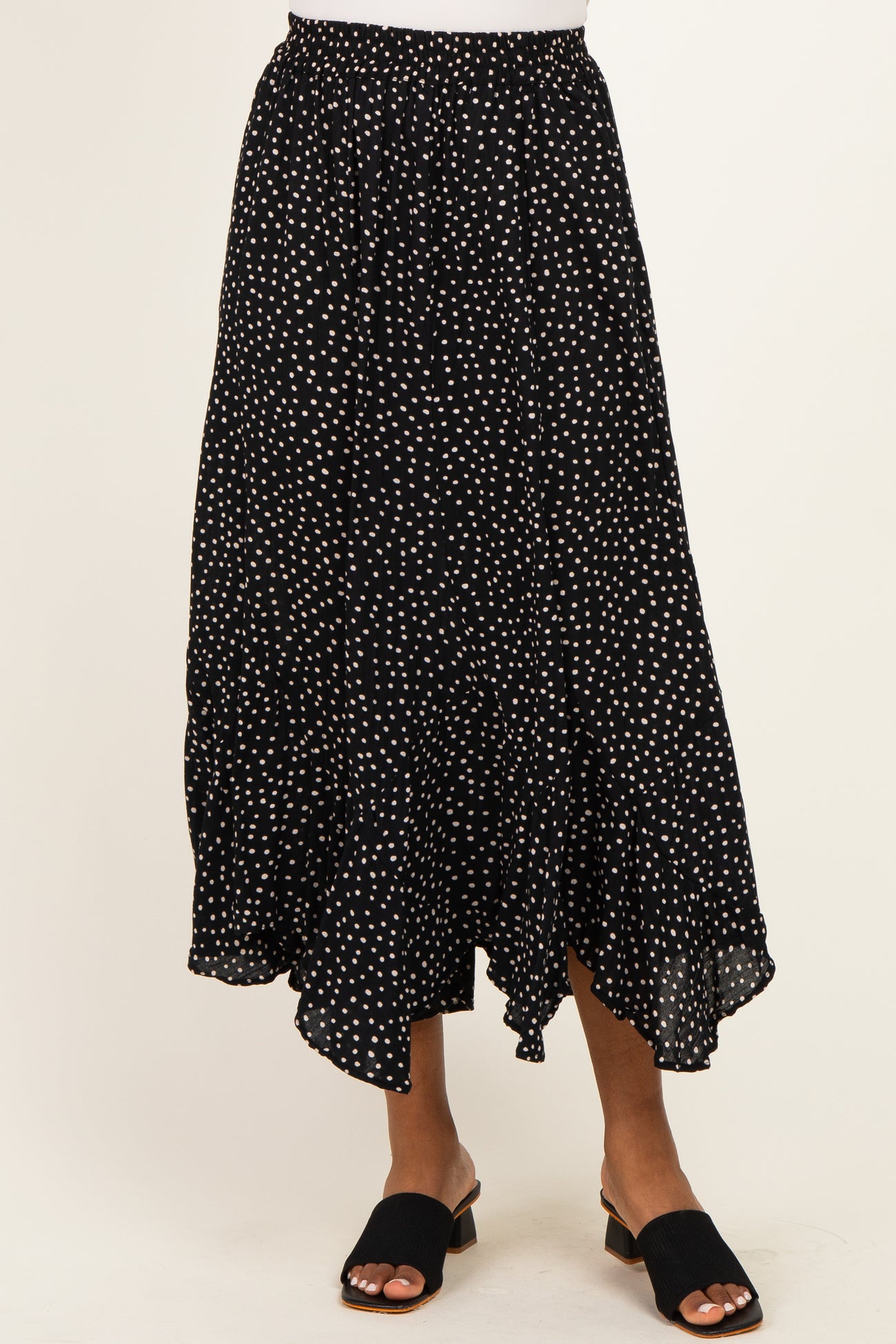 woman wearing a black polka dot maxi skirt with a tiered hem and an elastic waistband
