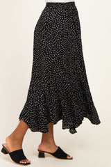 woman wearing a black polka dot tiered midi skirt and black open-toe block heel mules