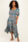 woman wearing a teal floral midi dress with puff sleeves and a high-low hemline