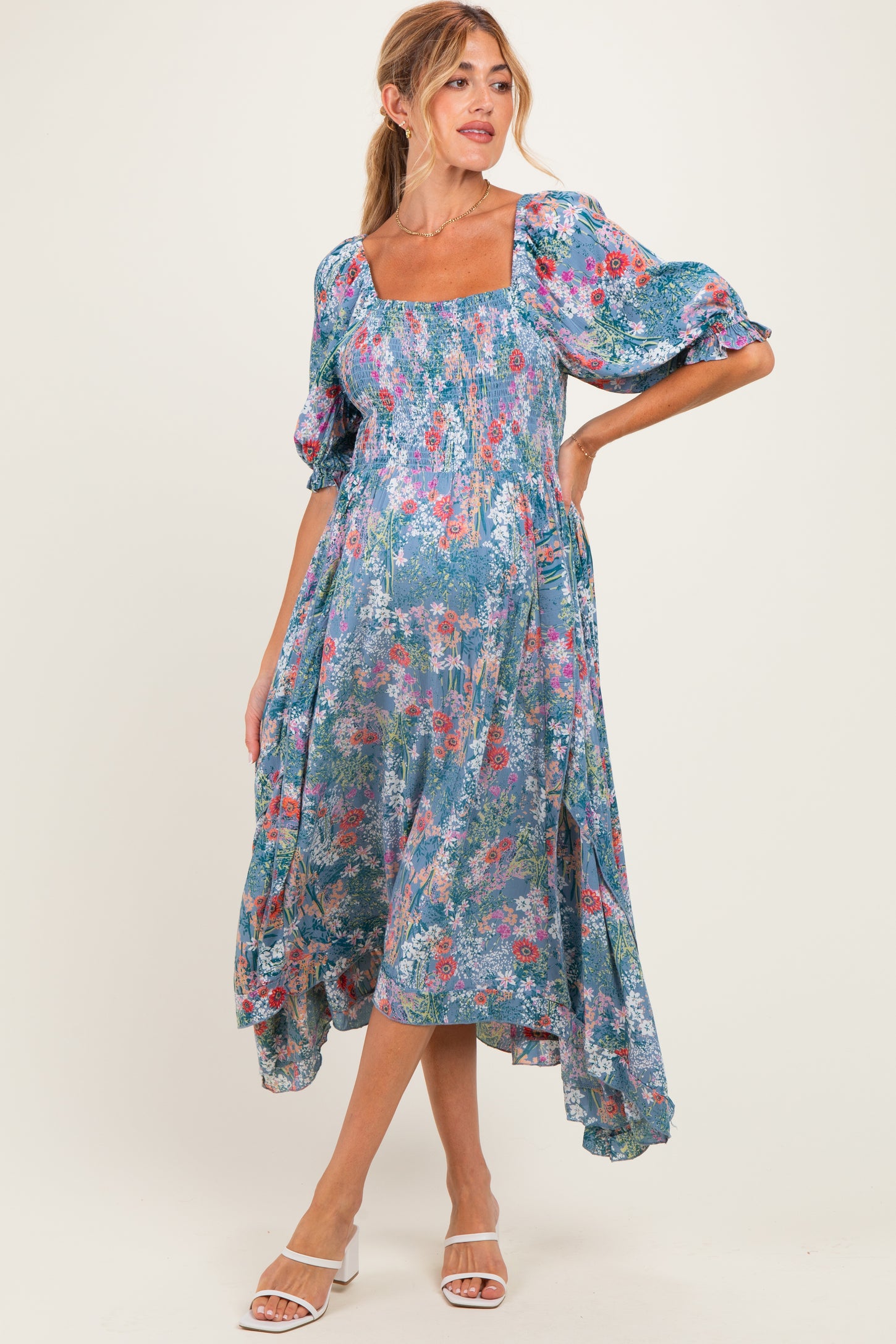 woman wearing a floral print maternity dress with puff sleeves and a square neckline, showing her baby bump