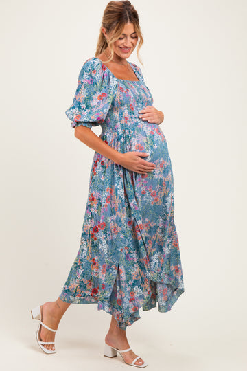 woman wearing a floral maxi maternity dress and holding her baby bump