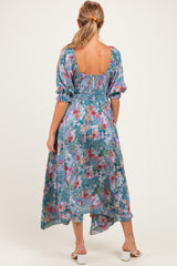 woman wearing a floral print maternity dress with puff sleeves and an open back, showing a baby bump