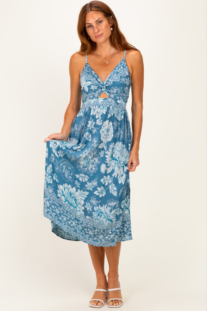 woman wearing a blue floral print maxi dress with a cutout detail and adjustable straps