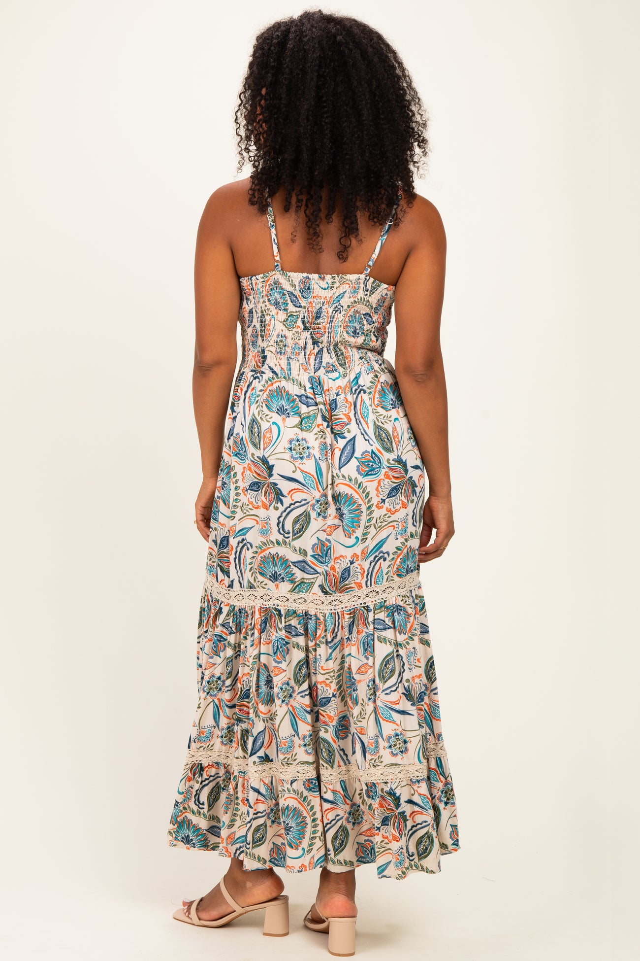 woman wearing a floral print maxi dress with smocked bodice and tiered skirt, shown from the back